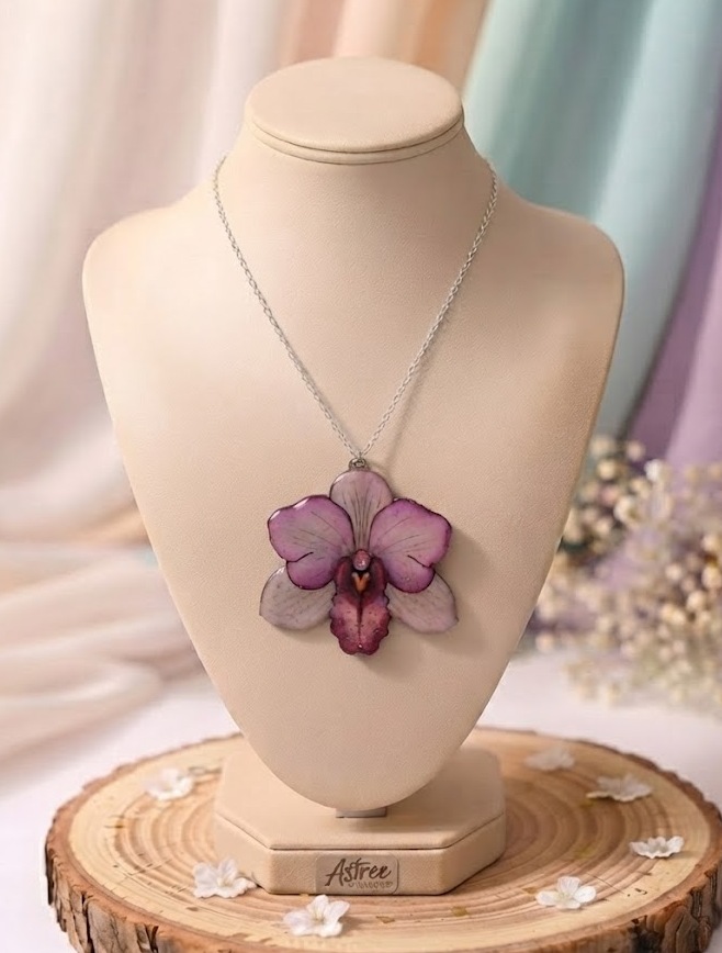 Laissez-vous séduire par ce collier en forme d'orchidée, une création artisanale réalisée à partir de l'un de mes dessins originaux. Chaque fleur est coulée en résine puis décorée de délicates paillettes et de quelques strass pour apporter une touche d'éclat tout en restant élégante. Caractéristiques : 🌸 Dessin original créé par Astrée Shines ✨ Réalisé en résine avec strass et paillettes 🔗 Chaîne en acier inoxydable de 45 cm 📏 Dimensions du pendentif : environ 5 cm de largeur × 4,6 cm de hauteur 🖐️ Fabrication artisanale en France Chaque création est réalisée à la main. De légères variations peuvent apparaître, rendant chaque collier unique.f5d6f3eb3d54