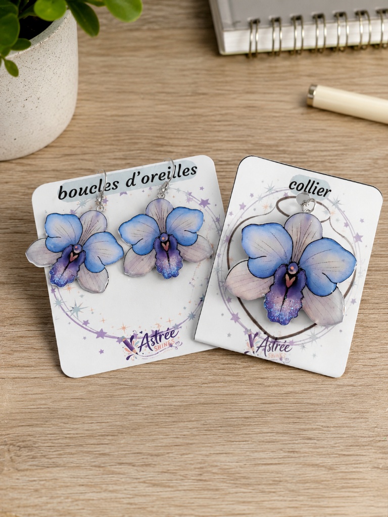 Laissez-vous séduire par ce collier en forme d'orchidée, une création artisanale réalisée à partir de l'un de mes dessins originaux. Chaque fleur est coulée en résine puis décorée de délicates paillettes et de quelques strass pour apporter une touche d'éclat tout en restant élégante. Caractéristiques : 🌸 Dessin original créé par Astrée Shines ✨ Réalisé en résine avec strass et paillettes 🔗 Chaîne en acier inoxydable de 45 cm 📏 Dimensions du pendentif : environ 5 cm de largeur × 4,6 cm de hauteur 🖐️ Fabrication artisanale en France Chaque création est réalisée à la main. De légères variations peuvent apparaître, rendant chaque collier unique.adb8b81dfb35